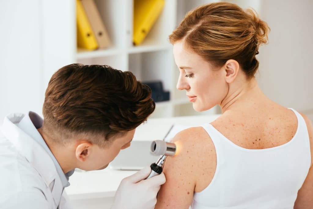 Dermatologist checking patient for moles and birthmarks